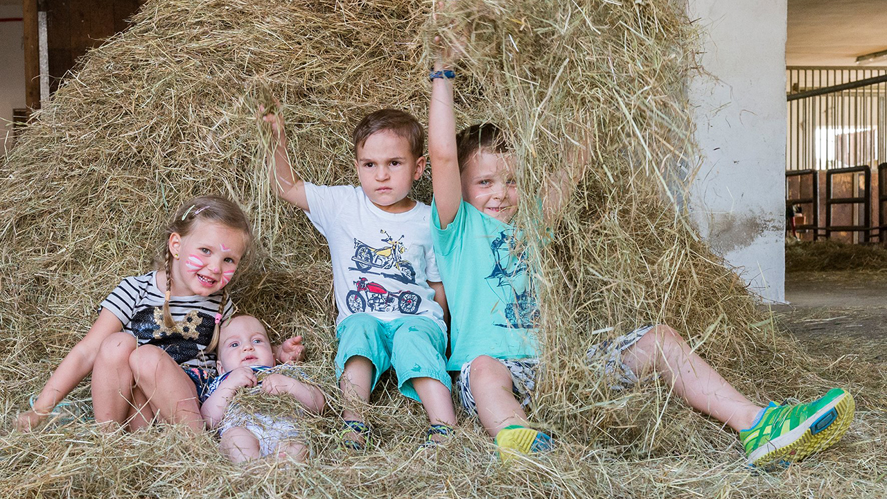 Kinder spielen im Heuhaufen