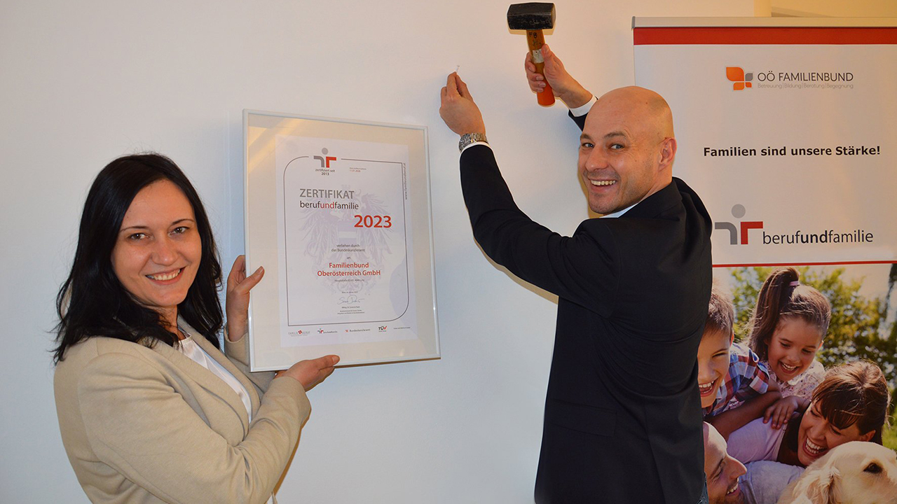 Ana Aigner und Martin Hajart nageln eine Auszeichnung an die Wand