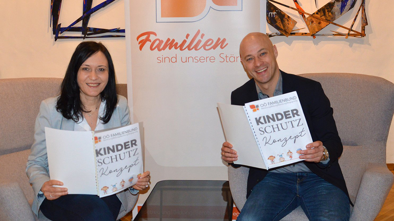 Martin Hajart und Ana Aigner haben ein Heft vom Kinderschutz und lesen darin