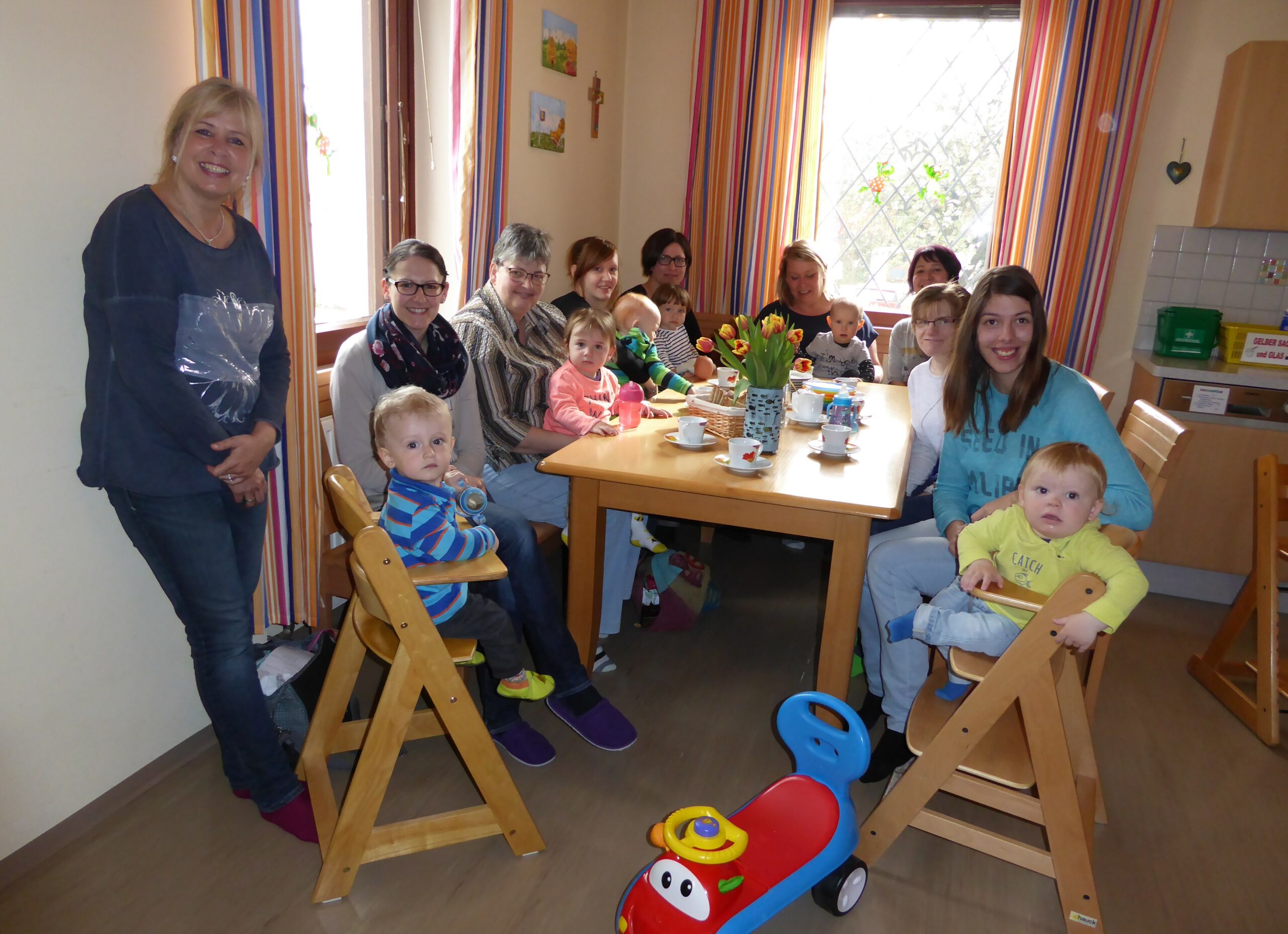 Gruppenfoto Mamas und Kleinkinder an einem Tisch