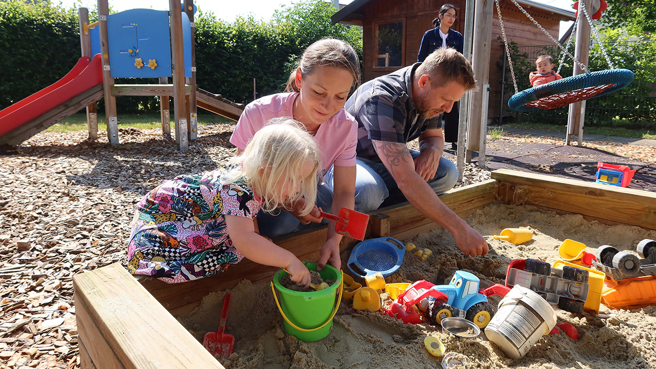 Familie spielt im Sand