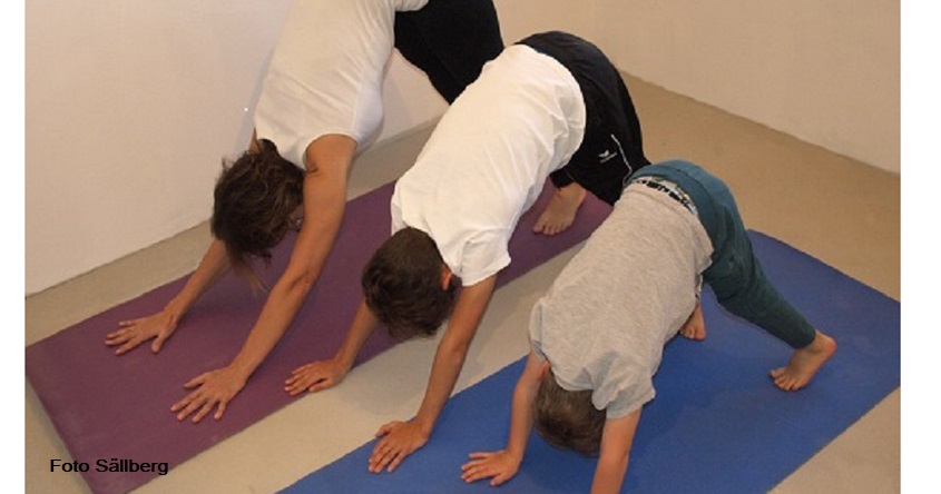 Kinder mit Mama machen eine Yoga Übung