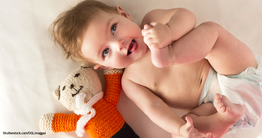 Baby mit Windel und Kuschelbär