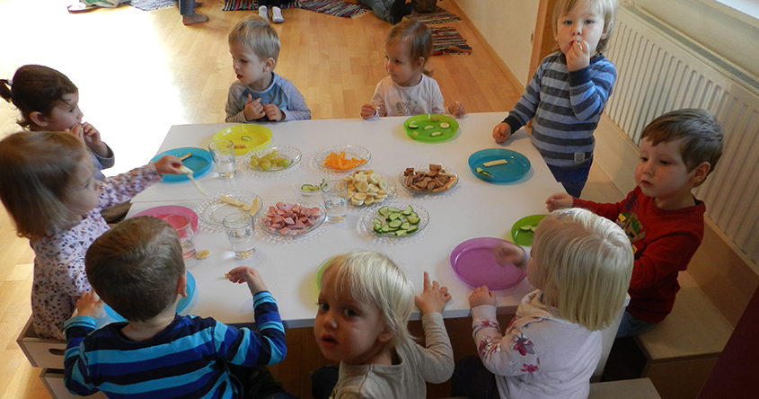 Kinder beim der Jause am Tisch