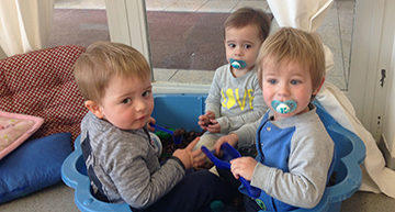 3 Kinder in einer blauen Wanne sitzend