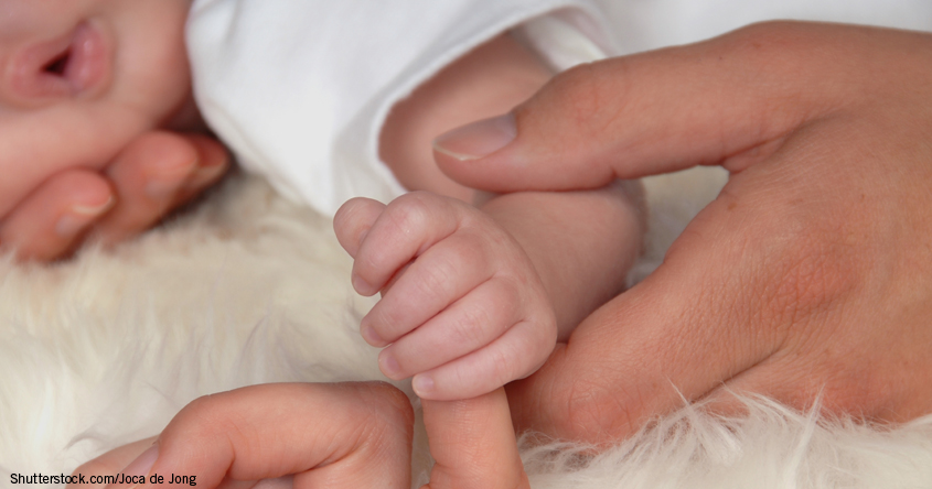 Babyhand mit Mama auf Lammfell