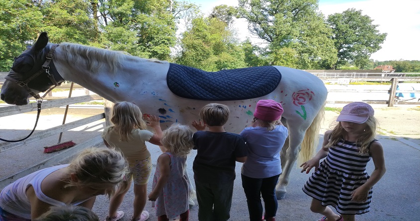 Kinder stehen vor einem Pferd