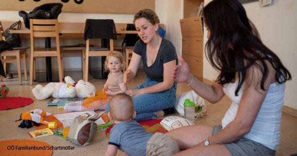 Mütter mit Kindern am Boden sitzend