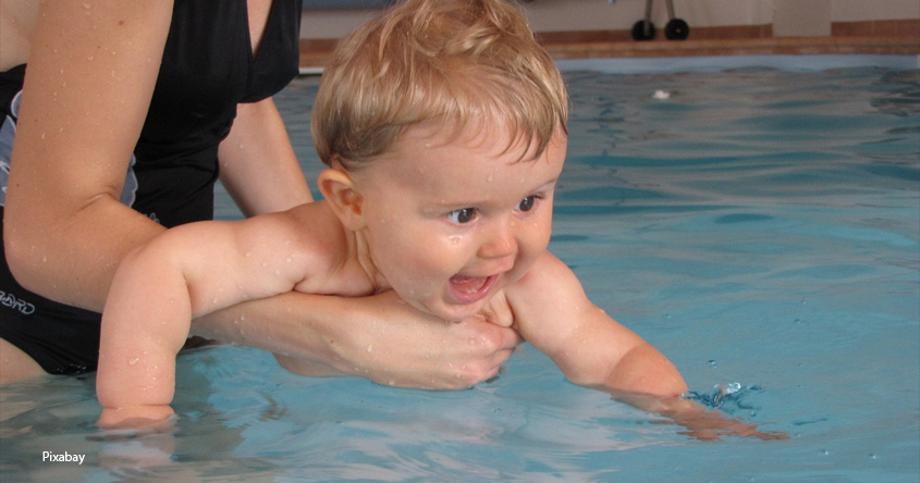 Mutter hält Baby im Wasser