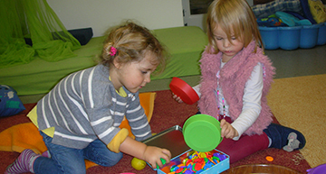 2 Kinder beim Schütten mit Perlen