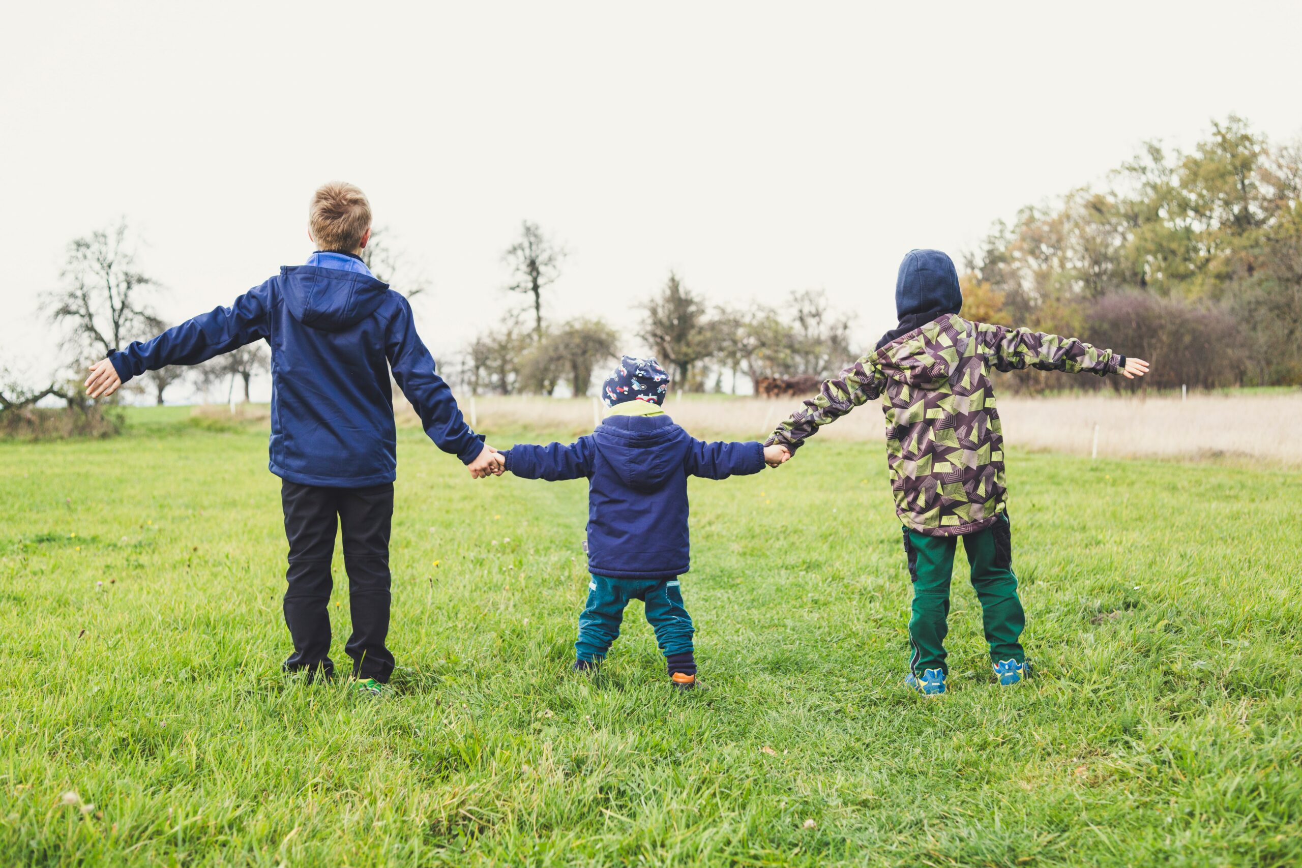 3 Kinder halten sich an den Händen